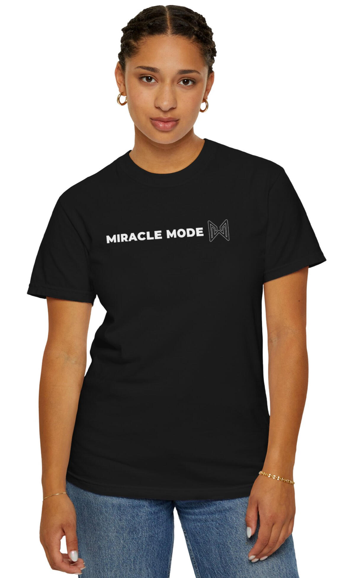 MERAQL Miracle Mode Essential Tee – Black Woman wearing a black MERAQL Miracle Mode T-shirt with horizontal white text and an outlined emblem across the center chest.